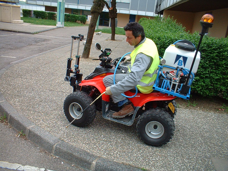 Quad équipé pour le traitement des trottoirs 